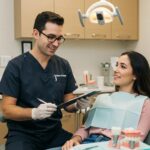 Dental clinic scene with a dentist and patient discussing dental implants, emphasizing care and professionalism