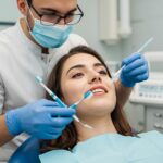Dental professional demonstrating dental implant care techniques with soft-bristle toothbrush and interdental brushes