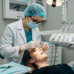 Dental professional examining a patient with dental implants in a modern clinic