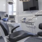 a modern dental clinic in mansfield, featuring a sleek, well-lit consultation room with advanced dental equipment, where a dental professional is discussing implant options with a patient.