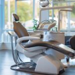 a serene and well-lit dental office setting showcases a compassionate dentist comforting an anxious patient in a modern treatment chair, emphasizing a warm and supportive atmosphere that alleviates dental fears.