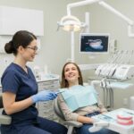 Smiling patient consulting with a dentist about dental veneers in a modern dental clinic