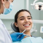 Smiling person with dental implants in a bright dental office, showcasing confidence and health