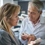 Dental consultation scene with a dentist explaining dental implants to a patient in a welcoming clinic