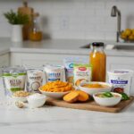 A colorful assortment of soft foods for dental implant recovery, including Greek yogurt and mashed sweet potatoes, promoting healing and nutrition.