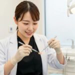 Dental professional examining a dental implant model in a modern clinic