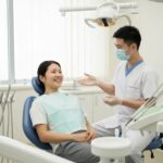 Patient and dentist discussing dental implant recovery in a modern clinic