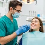 Dental professional discussing dental implants and bridges with a patient in a modern clinic
