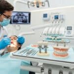 Dental professional discussing dental implants and bridges with a patient in a modern clinic
