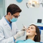 Dental professional examining a patient for dental implant failure symptoms in a modern clinic