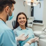 Smiling patient consulting with a dentist about dental implants in a warm dental clinic