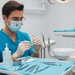 Dental clinic scene with a dentist preparing for tooth extraction, emphasizing professional care