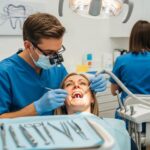 Dental professional examining a dental implant in a clinical setting