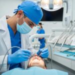 Dental professional examining a dental implant in a clinical setting