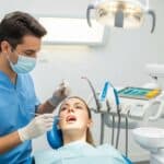 Dental professional examining a patient for tooth extraction in a modern clinic