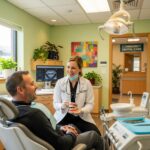 Friendly dentist consulting with a low-income patient in a welcoming dental clinic