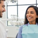 Smiling person with dental implants in a bright dental office, showcasing the benefits of dental restoration