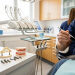 Dental professional examining dental implants, bridges, and dentures in a modern dental office