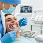 Dental professional examining a patient for dental bridges and implants