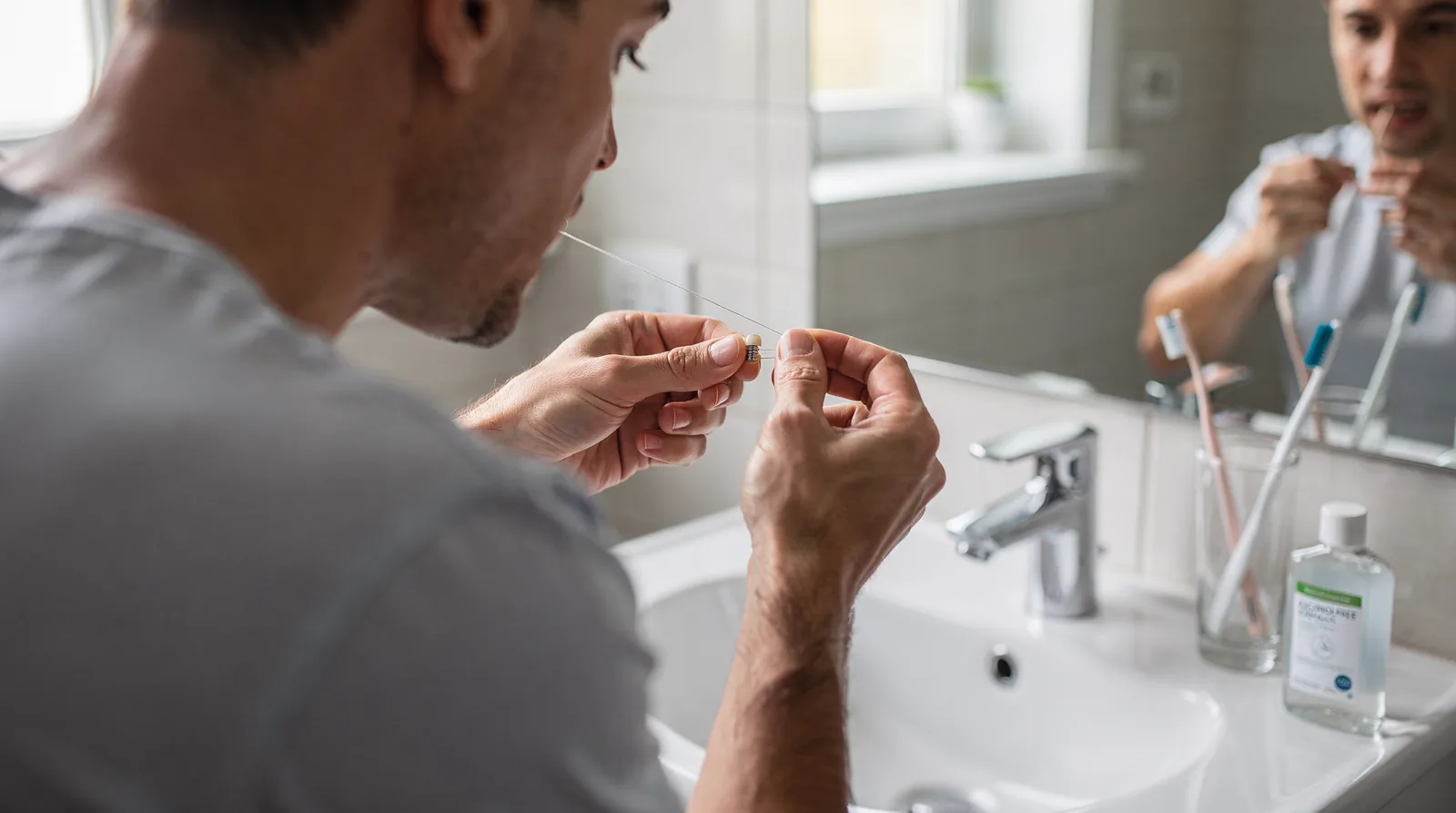 Brush twice daily with a soft-bristled toothbrush and low-abrasive toothpaste to avoid scratching the implant